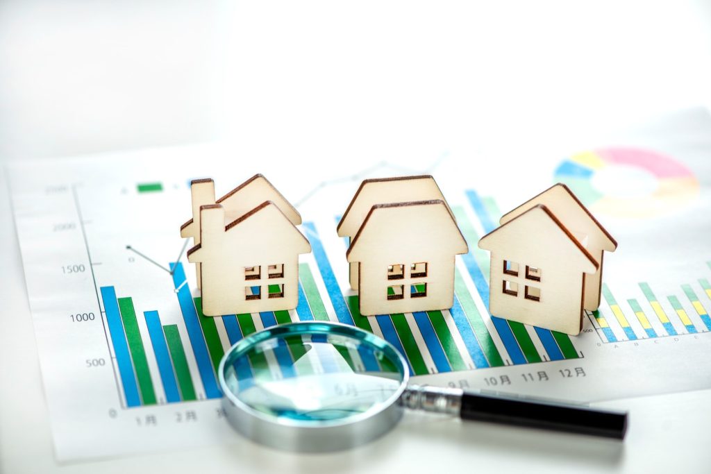 住宅模型と虫眼鏡、データの資料