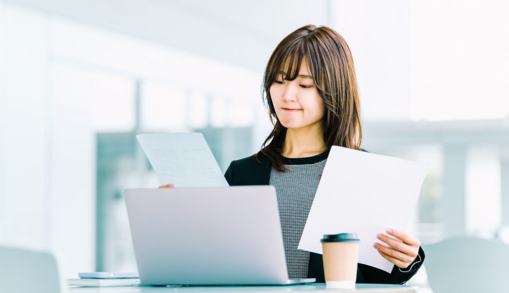 書類を見て考える女性