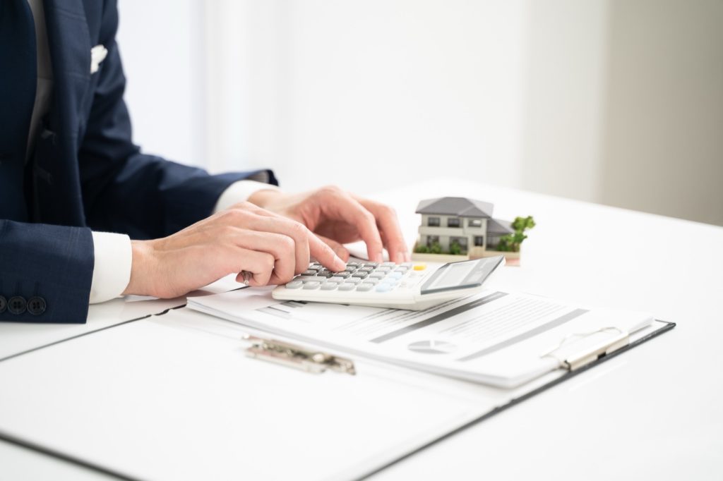 家の売却にかかる費用を計算する不動産会社の社員